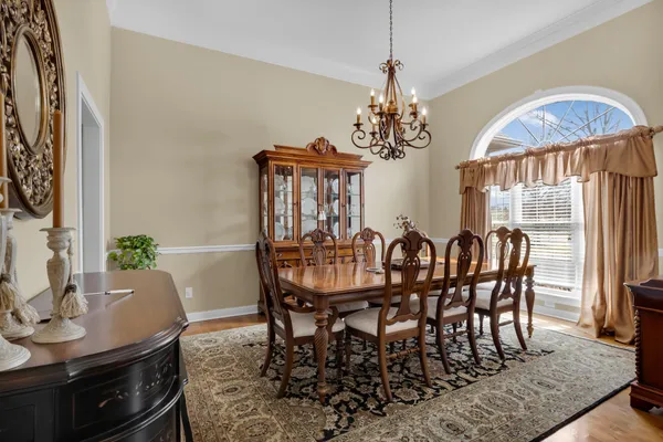 a dining room with furniture a chandelier and wooden floor