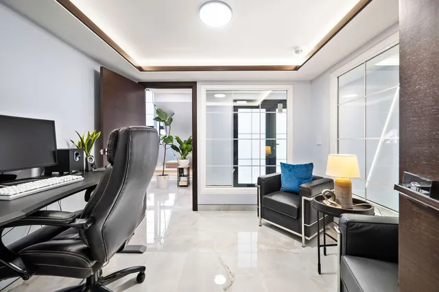 a view of a livingroom with workspace and a window