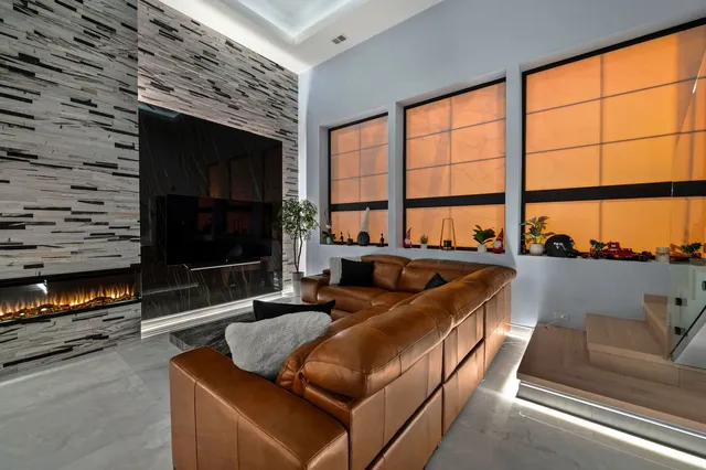 a living room with furniture a flat screen tv and a fireplace