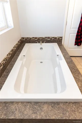 a view of a bathroom with bathtub and shower
