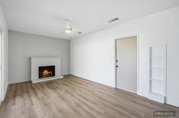 a view of an empty room with a fireplace and a window