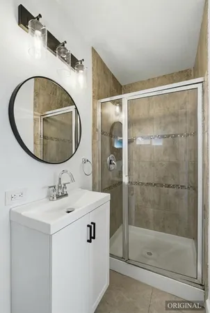 a bathroom with a sink mirror and shower
