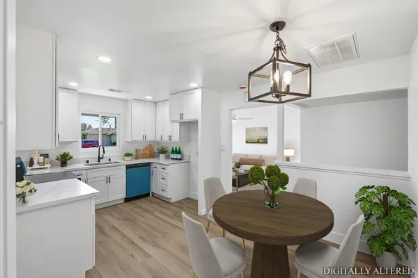 a kitchen with stainless steel appliances a sink a table and chairs in it