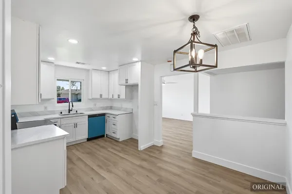 a kitchen with a sink cabinets and wooden floor