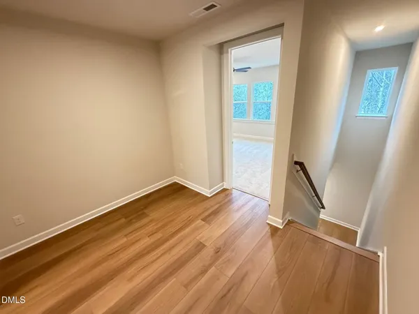 a view of empty room with wooden floor