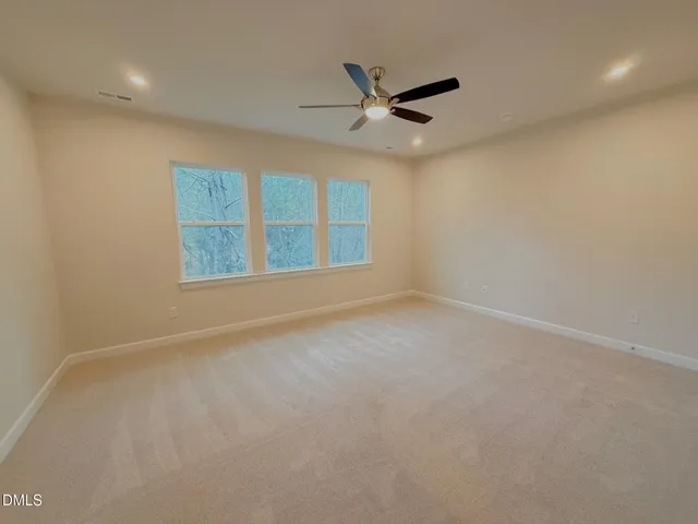an empty room with a window and ceiling fan