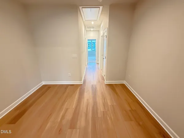 a view of a room with wooden floor and white walls
