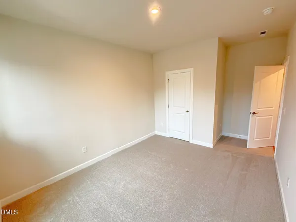 an empty room with closet and wooden floor