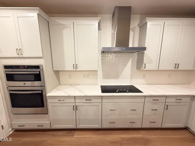 a kitchen with white cabinets and white appliances