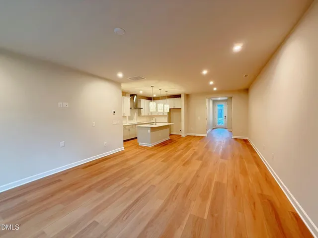 a view of empty room with wooden floor and fireplace