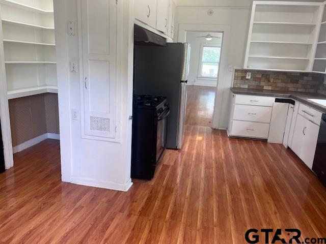 617 West Dobbs Street Tyler, TX 75701 - Photo 10 of 19 a kitchen with white cabinets and wooden floor