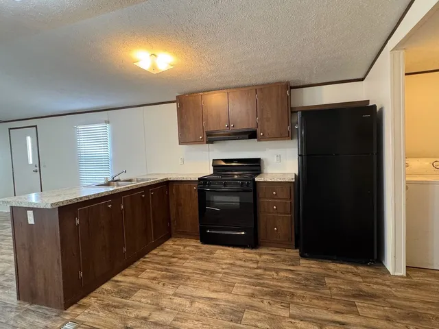 a kitchen with stainless steel appliances granite countertop a refrigerator and a stove top oven
