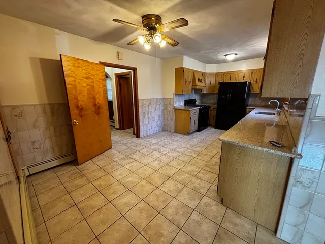 a kitchen with stainless steel appliances granite countertop a refrigerator a stove and a sink
