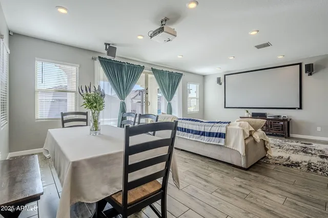 a kitchen with stainless steel appliances granite countertop a stove a sink a refrigerator with a dining table and chairs