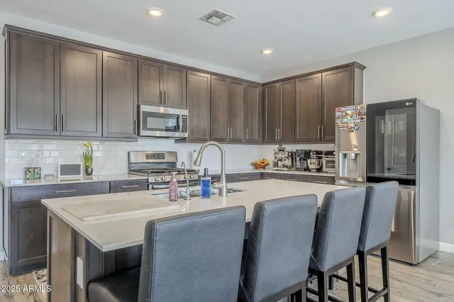 a kitchen with stainless steel appliances kitchen island granite countertop a sink counter top space and cabinets