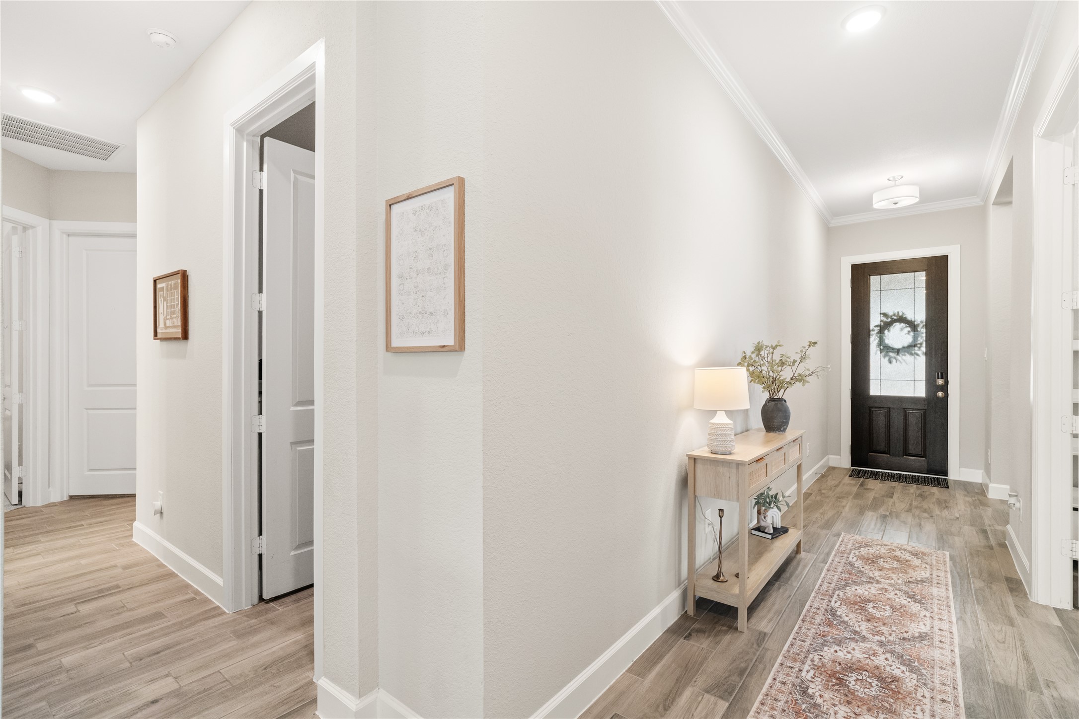 3118 Swift Way Katy, TX 77493 - Photo 3 of 34 Hallway / Entry Corridor – A welcoming interior hallway with high ceilings, clean lines, and wood-look flooring that creates a cohesive flow throughout the home.
