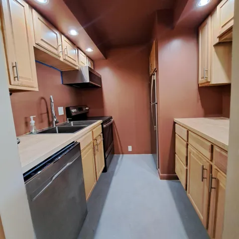 a kitchen with stainless steel appliances a sink a stove and a refrigerator