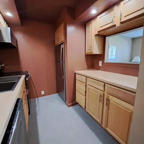 a kitchen with white cabinets and sink