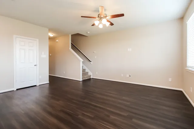 a view of a room with wooden floor and a ceiling fan