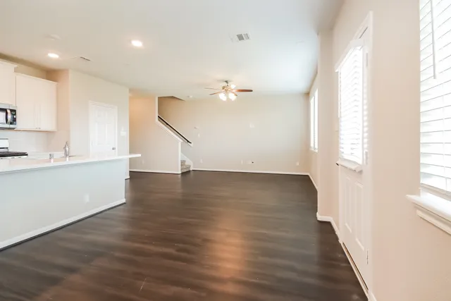a view of a kitchen with wooden floor and a window
