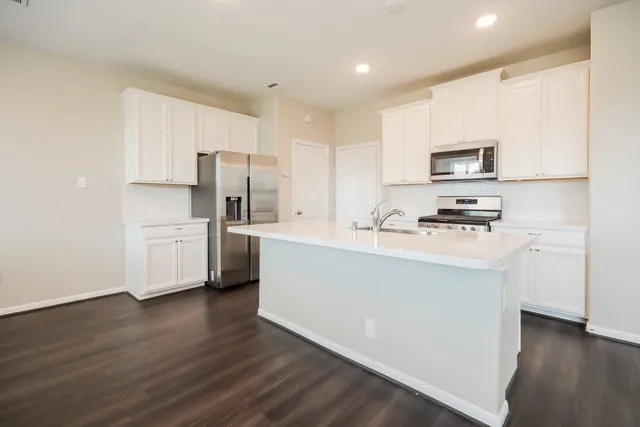 a kitchen with stainless steel appliances a refrigerator sink and microwave
