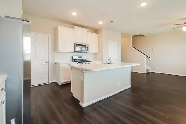 a kitchen with stainless steel appliances a white stove top oven and a refrigerator