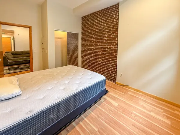 a bedroom with a bed and a flat tv screen on dresser