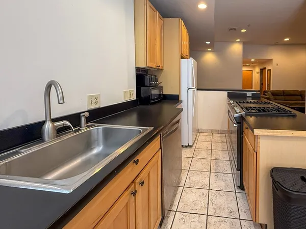 a kitchen with kitchen island a sink appliances and cabinets