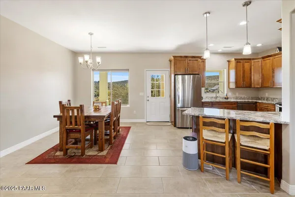 a view of a kitchen with dining room and wooden shelves