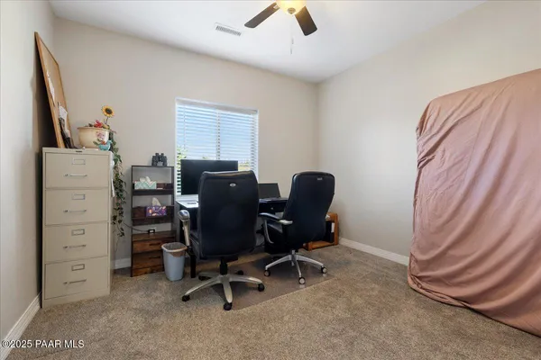 a view of a workspace with furniture and a window