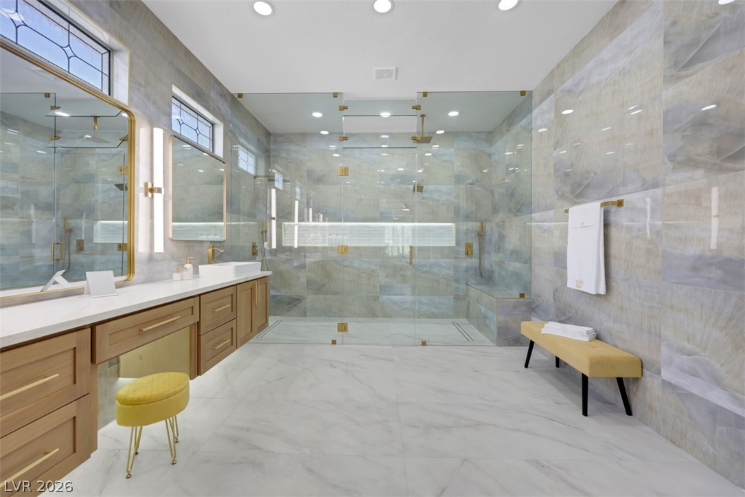 Luxurious walk-in shower and ample counter space define this generously proportioned primary bathroom.