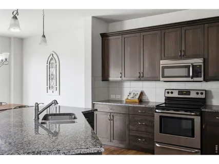 a kitchen with stainless steel appliances a stove a sink and a microwave