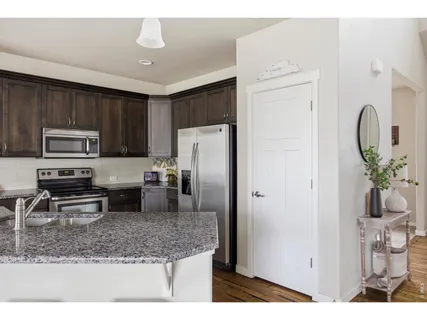 a kitchen with stainless steel appliances granite countertop a refrigerator a stove a sink a counter space and refrigerator