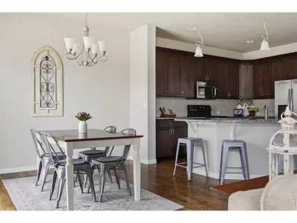 a kitchen with kitchen island granite countertop a dining table chairs and white cabinets
