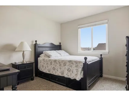 a bedroom with a bed and a lamp on dresser