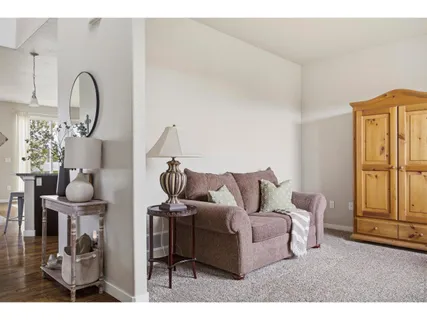 a living room with furniture a rug and white walls