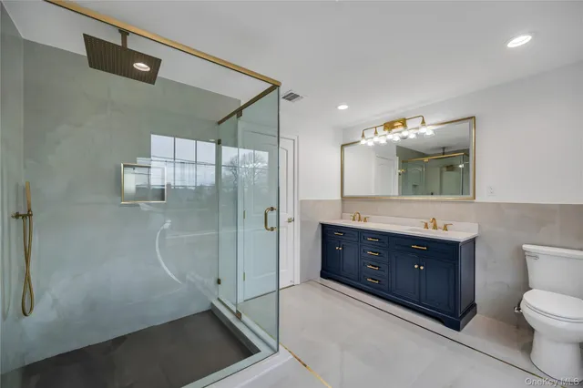 a bathroom with a sink vanity granite toilet and shower