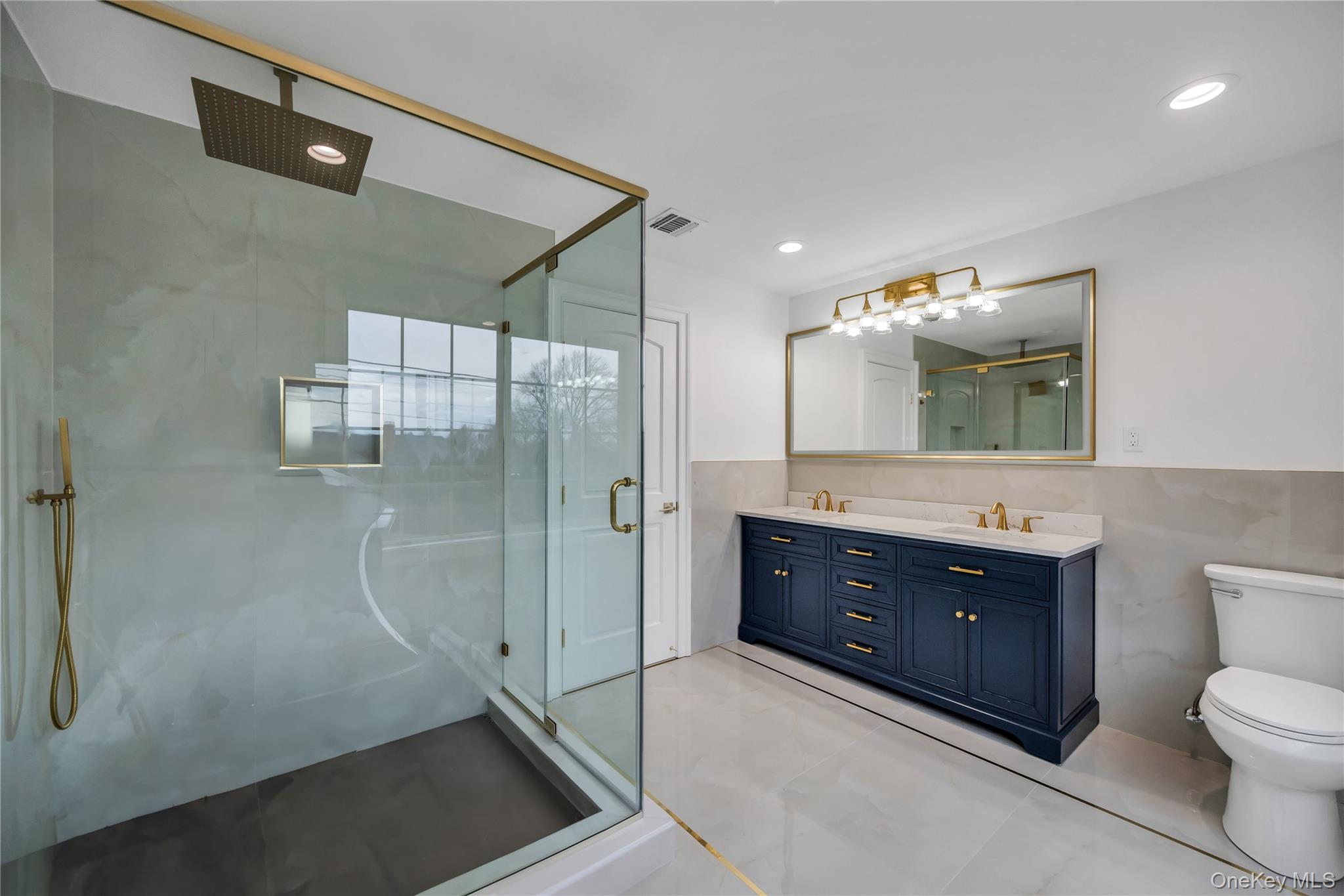319 Blacksmith Road Levittown, NY 11756 - Photo 15 of 16 Bathroom featuring tile walls, a marble finish shower, double vanity, toilet, and recessed lighting