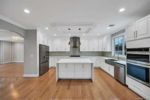 a large kitchen with cabinets wooden floor and stainless steel appliances