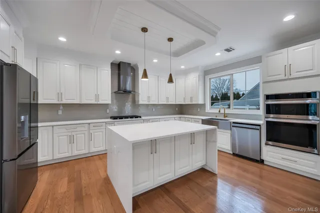 a kitchen with a white cabinets and wooden floor