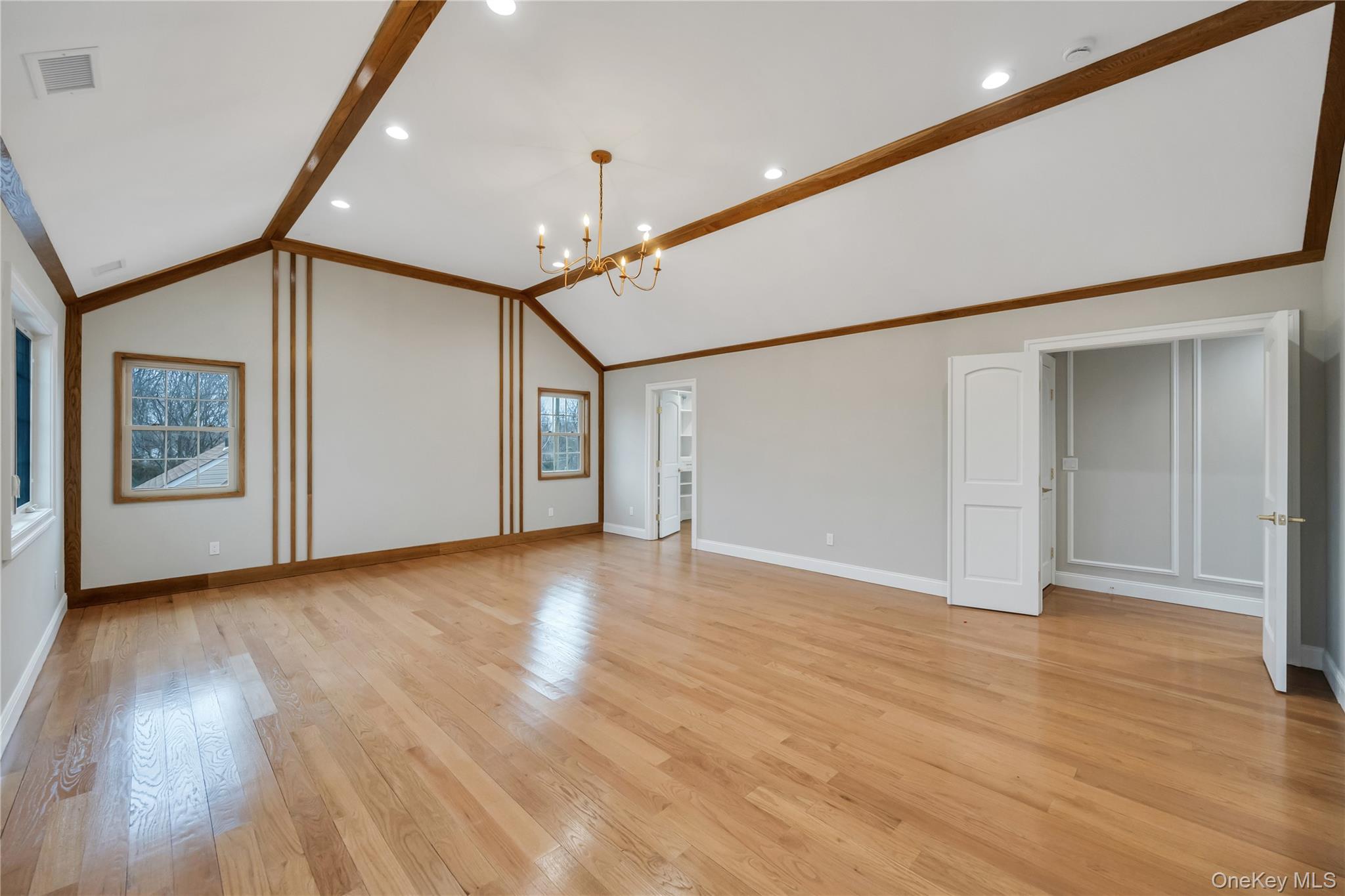 319 Blacksmith Road Levittown, NY 11756 - Photo 10 of 16 Unfurnished living room featuring a chandelier, light wood finished floors, lofted ceiling, baseboards, and recessed lighting