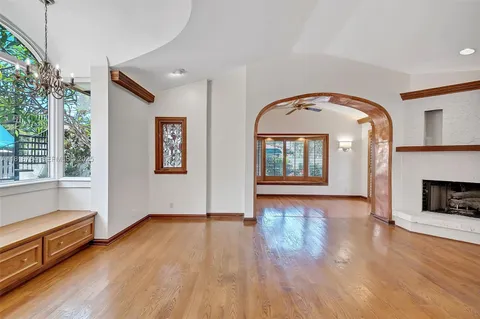 a view of an empty room with window wooden floor and fire place