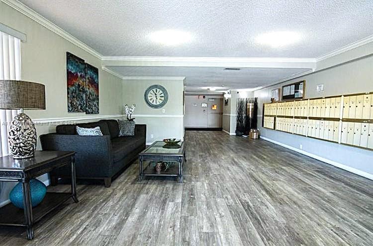 22605 Southwest 66th Avenue, Unit 409 Boca Raton, FL 33428 - Photo 2 of 19 a living room with couch and a wooden floor