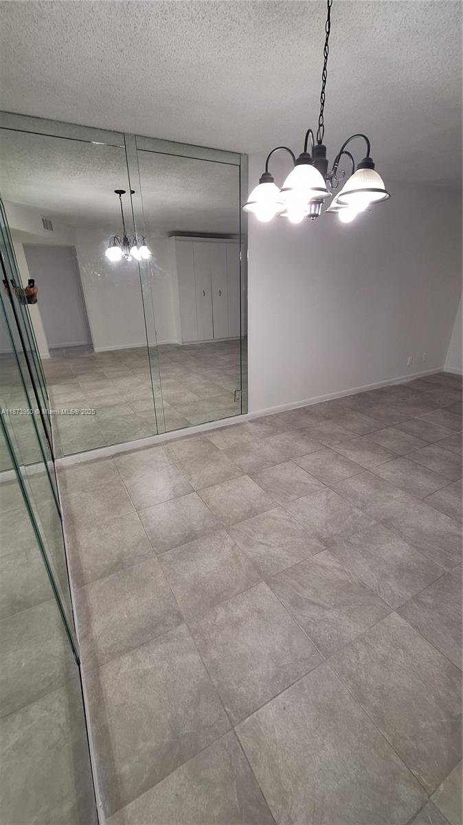 22605 Southwest 66th Avenue, Unit 409 Boca Raton, FL 33428 - Photo 4 of 19 a view of an empty room with a chandelier fan