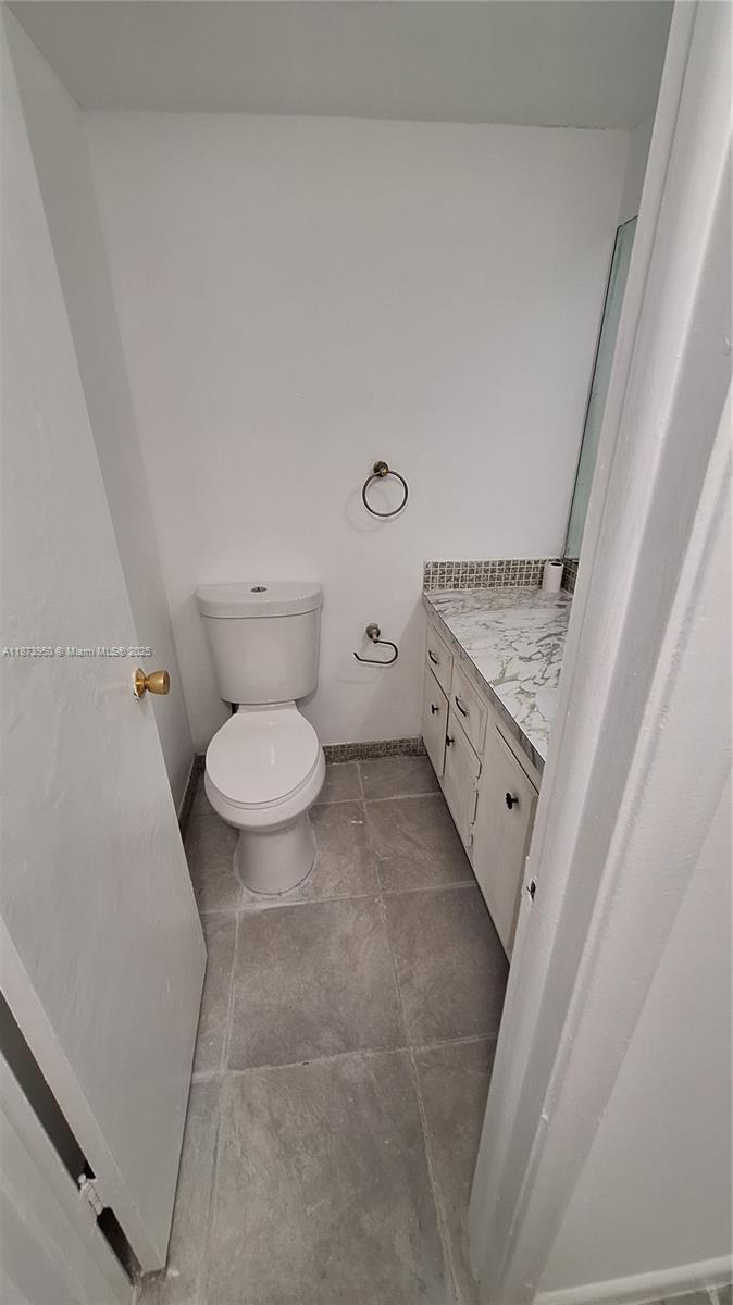 22605 Southwest 66th Avenue, Unit 409 Boca Raton, FL 33428 - Photo 10 of 19 a bathroom with a granite countertop toilet and a sink