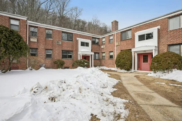 a front view of a house with a yard covered in snow