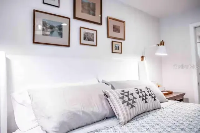 a bedroom with a large bed and a chandelier