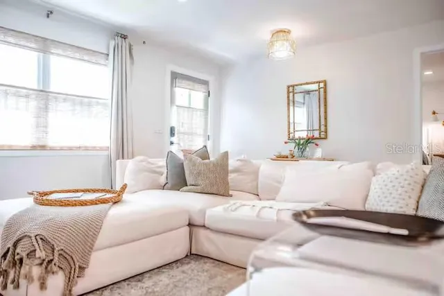 a living room with a bed furniture and a window