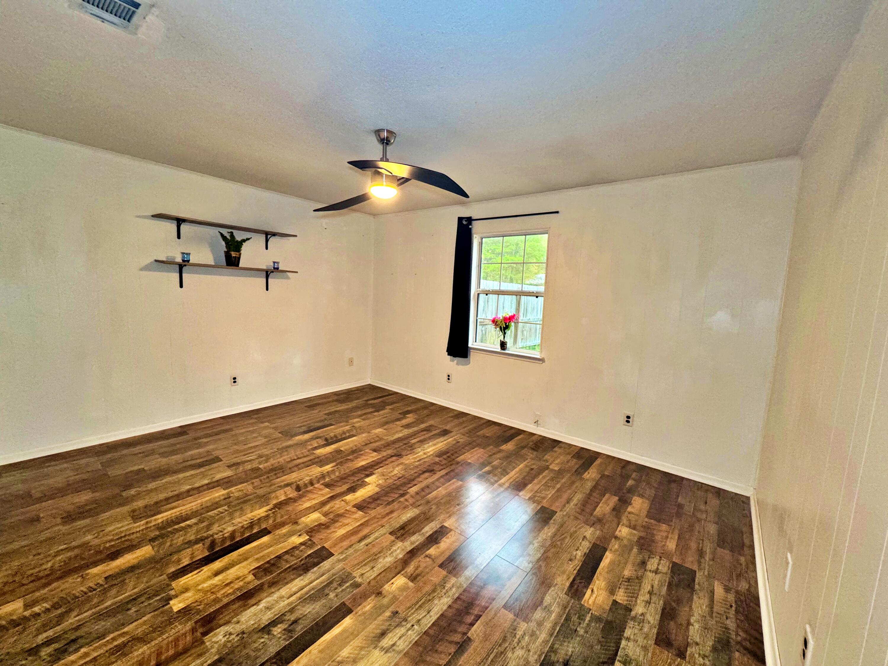 3183 Audrey Drive Crestview, FL 32539 - Photo 8 of 14 a view of empty room with wooden floor and fan