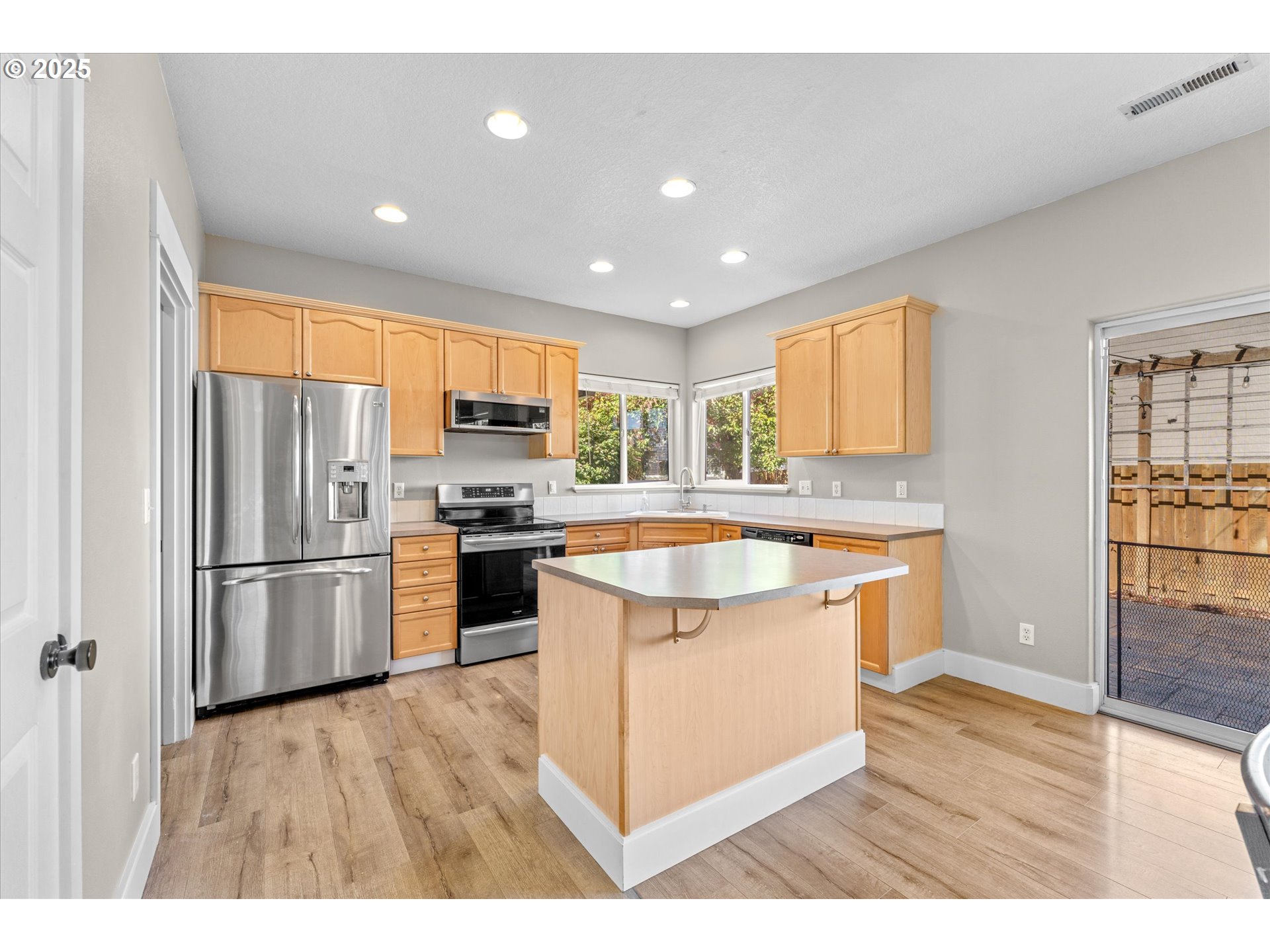 6475 Southeast 33rd Way Gresham, OR 97080 - Photo 13 of 47 a kitchen with stainless steel appliances granite countertop a refrigerator a sink dishwasher a stove and white countertops with wooden floor